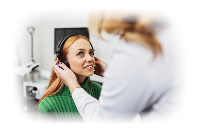 A female clinician places headphones on a female patient